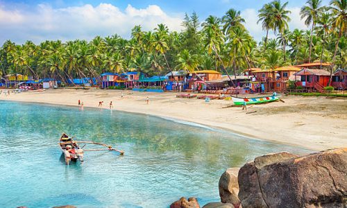 Beautiful Goa province beach in India with fishing boats and stones in the sea